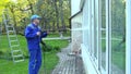 Man wash glass windows with water pressure jet.