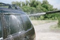 A man washes a car with a high pressure washer