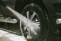 A man washes a car with a high pressure washer