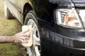 Man washes a car sponge with an aluminum alloy car shampoo Royalty Free Stock Photo