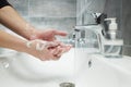 A man washes his hands with antibacterial soap under a tap with water. Treats hands with an antiseptic Royalty Free Stock Photo
