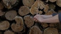 A man washes his hands on the background of cut logs