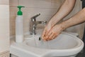 A man washes his hands with liquid soap under running water in the bathroom at home Royalty Free Stock Photo