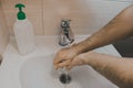 A man washes his hands with liquid soap under running water in the bathroom at home Royalty Free Stock Photo