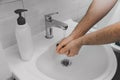 A man washes his hands with liquid soap under running water. Royalty Free Stock Photo