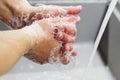 A man washes his hands with soap under the tap under running water close-up. Health, and hygiene concept Royalty Free Stock Photo