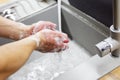 A man washes his hands with soap under the tap under running water close-up. Health, and hygiene concept. Royalty Free Stock Photo