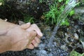 A man washes his hands at a spring in the forest. Blurred back natural background