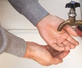 A man washes his hands with tap water from an old authentic copper tap, summer, outdoor, close-up Royalty Free Stock Photo