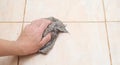 A man washes a tiled floor with a rag. Royalty Free Stock Photo