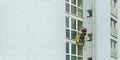 A man washes windows in a multi-storey building
