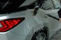 Man washing a car with a brush spreading shampoo over it. Royalty Free Stock Photo