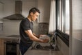 Man washing dishes in the kitchen. Medium shot