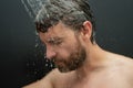 Man washing hair in bathroom. Guy bathing shower head in bathtub. Male face in shower. Man taking shower in bathroom Royalty Free Stock Photo