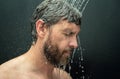 Man washing hair, close up portrait. Man bathing shower washing hair head in bathroom. Male model washing hair in shower