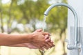 Man washing hand after working with outdoor faucet sink, cleaning hygiene protection concept with flowing water and green forest Royalty Free Stock Photo