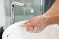 Man washing hands with soap over sink in bathroom Royalty Free Stock Photo