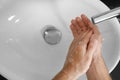 Man washing hands with soap over sink in bathroom Royalty Free Stock Photo