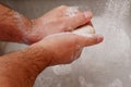 Man washing hands with soap in sink with running water Royalty Free Stock Photo