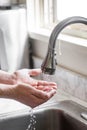 Man Washing Hands at Kitchen Sink Under Running Water Royalty Free Stock Photo