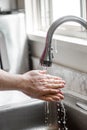 Man Washing His Hands with Soap and Water at Kitchen Sink Royalty Free Stock Photo