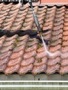 Man is washing the roof with a high pressure washer