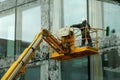 A man washing windows and facade of a building with a mop.