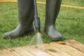 Man Washing Wooden Decking With Pressure Washer