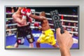 Man is watching boxing match on TV