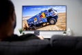 Man watching Dakar rally race on smart TV. Sports Live transmission concept.