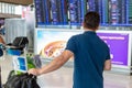 Man watching flight information display screen to check on his f