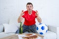 Man watching football game on television nervous and excited suffering stress fingers crossed for goal Royalty Free Stock Photo