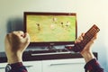 Man watching football match on television at home.