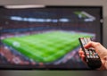 Man watching football match on television, the remote control in hand Royalty Free Stock Photo