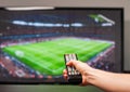 Man watching football match on television, the remote control in hand Royalty Free Stock Photo