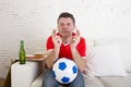 Man watching football on tv nervous and excited suffering stress crossing fingers for goal Royalty Free Stock Photo