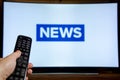 Man watching News on TV and using remote controller Royalty Free Stock Photo