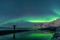 Man watching the northern lights, Aurora Borealis, Devil Teeth mountains in the background, Tungeneset, Senja, Norway