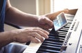 Man watching piano tutorial video with mobile phone. Person practising playing with an online lesson and course.