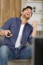 man watching television making victory gesture