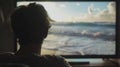 A man is watching a television screen that shows a beach Royalty Free Stock Photo