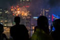 Man watching the 4th of July fireworks over water Royalty Free Stock Photo