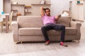 Young man watching tv at home during pandemic Royalty Free Stock Photo