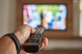 Man watching TV in the room and switches channels using the remote control in his hand Royalty Free Stock Photo