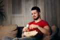 Man Watching TV While Snacking on Pop Corn