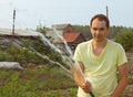 Man watering garden in the summer afternoon.