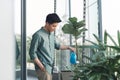 Man watering house plants on the balcony Royalty Free Stock Photo