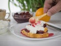 Man watering plum jam toasted French bread with curd cream. Royalty Free Stock Photo