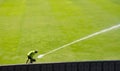 Man watering rawn football grass field Royalty Free Stock Photo