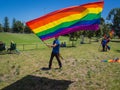 Man waving giant gay pride Rainbow Flag